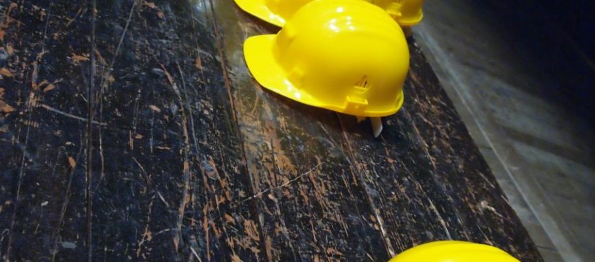 five yellow hard hats on gray surface