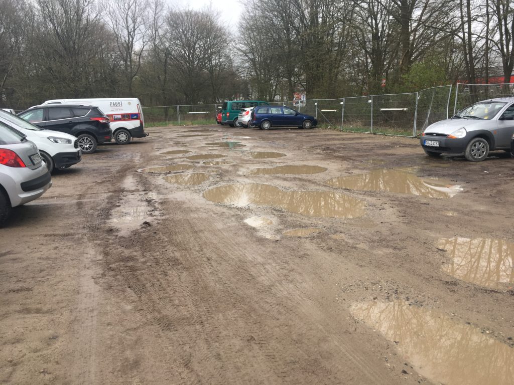 Der provisorische Parkplatz, der für die Bauphase eingerichtet wurde, ist abends komplett voll – trotz Schlaglöchern und teils riesigen Pfützen